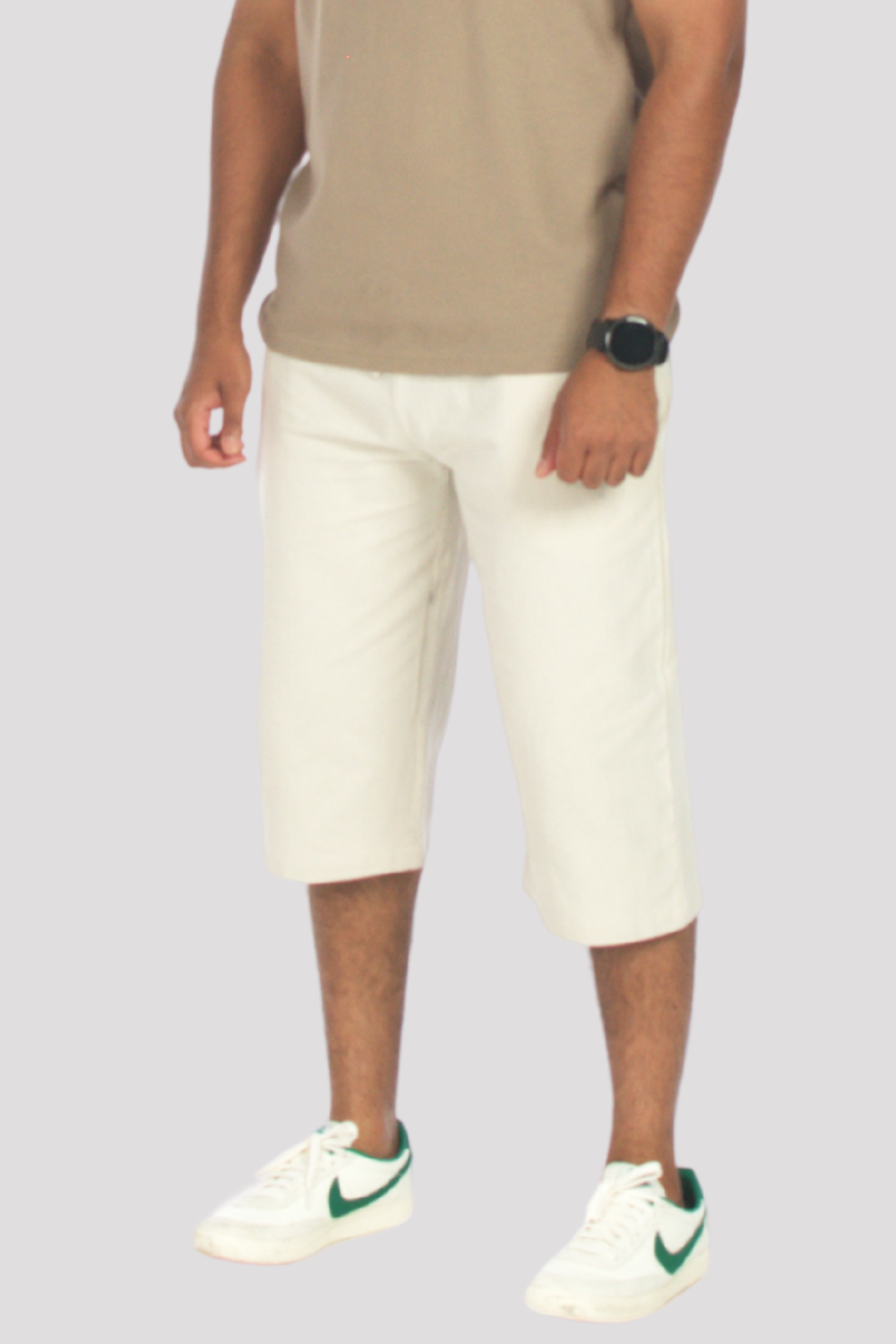 Person wearing a taupe polo shirt, stone shorts on a light gray background